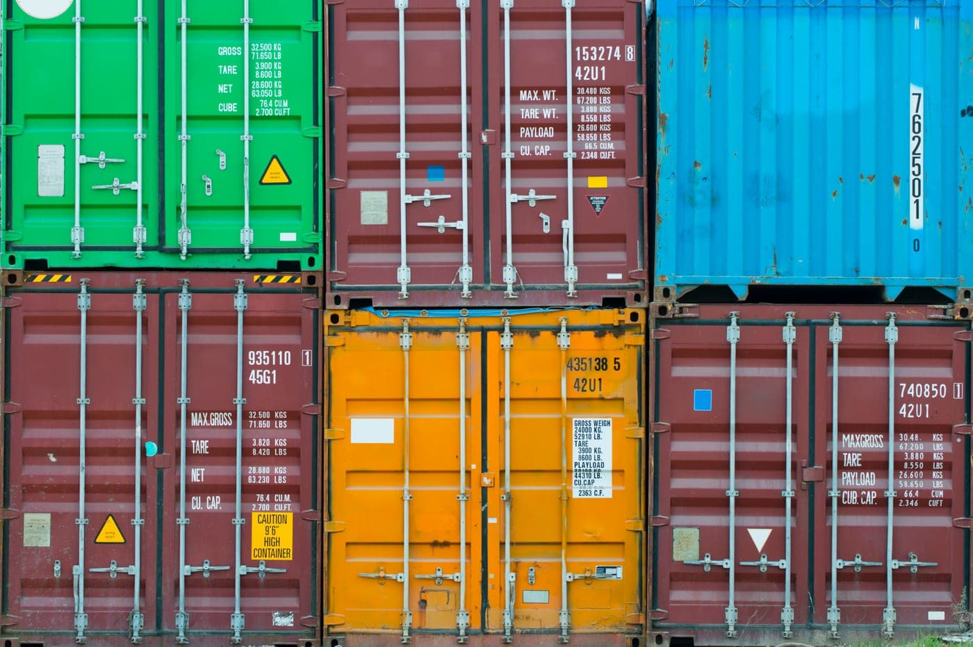 Colorful shipping containers stacked at a freight terminal